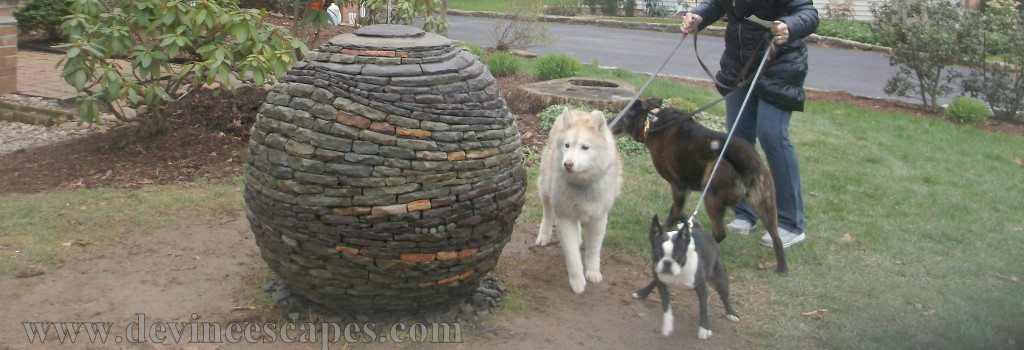 dry stone sphere garden sculpture with dogs