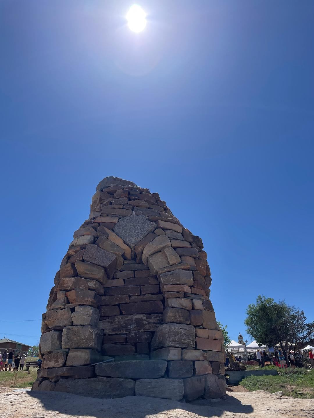 a 9 foot tall dry stone tower with archway built into it