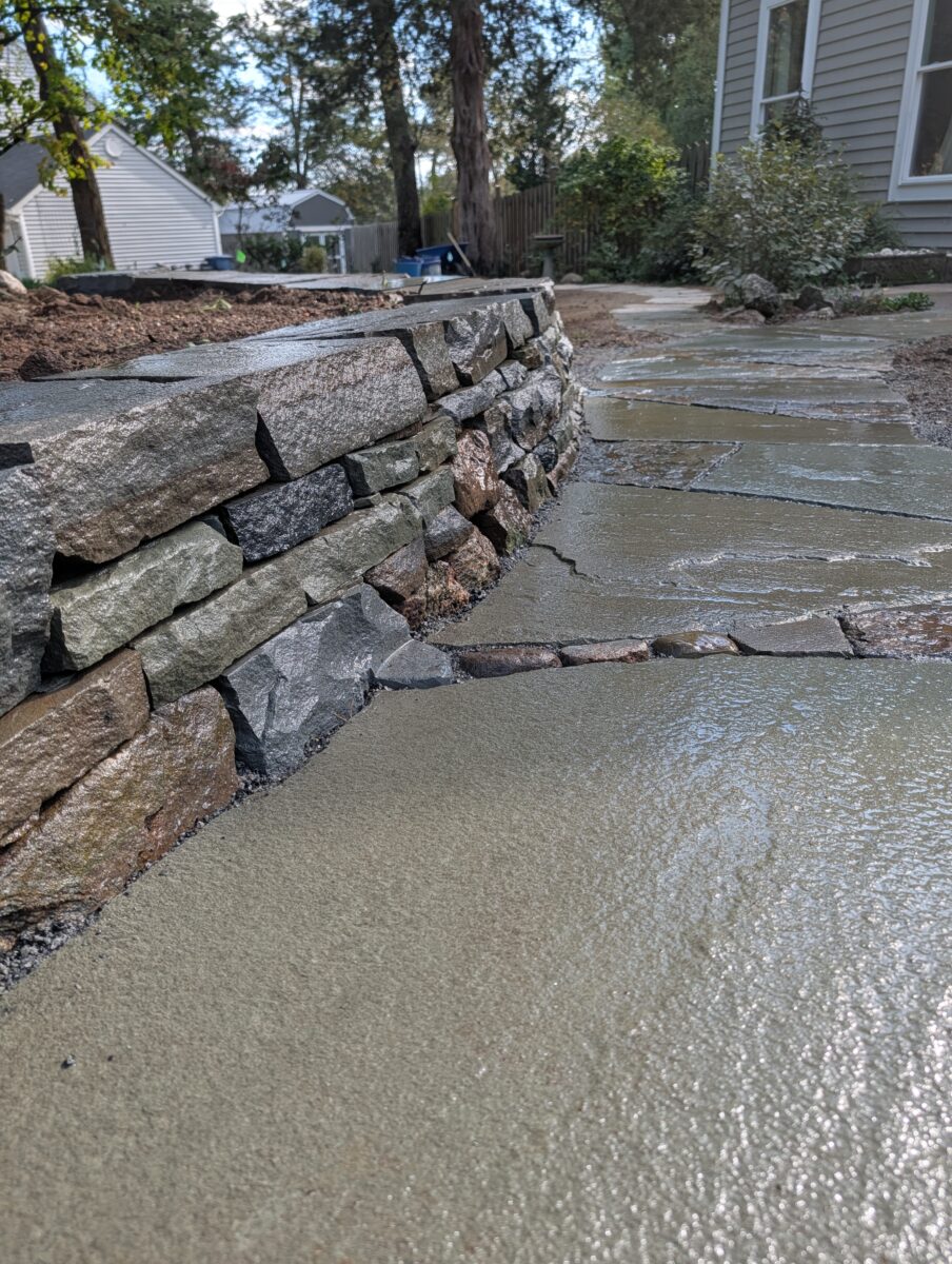 closeup photo of flagstone path integrated with stone wall